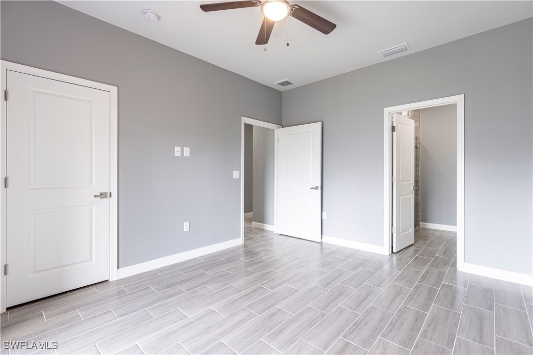 2422 Mae Avenue South Lehigh Acres, FL 33973 - Photo 13 of 28 an empty room with wooden floor chandelier and entryway