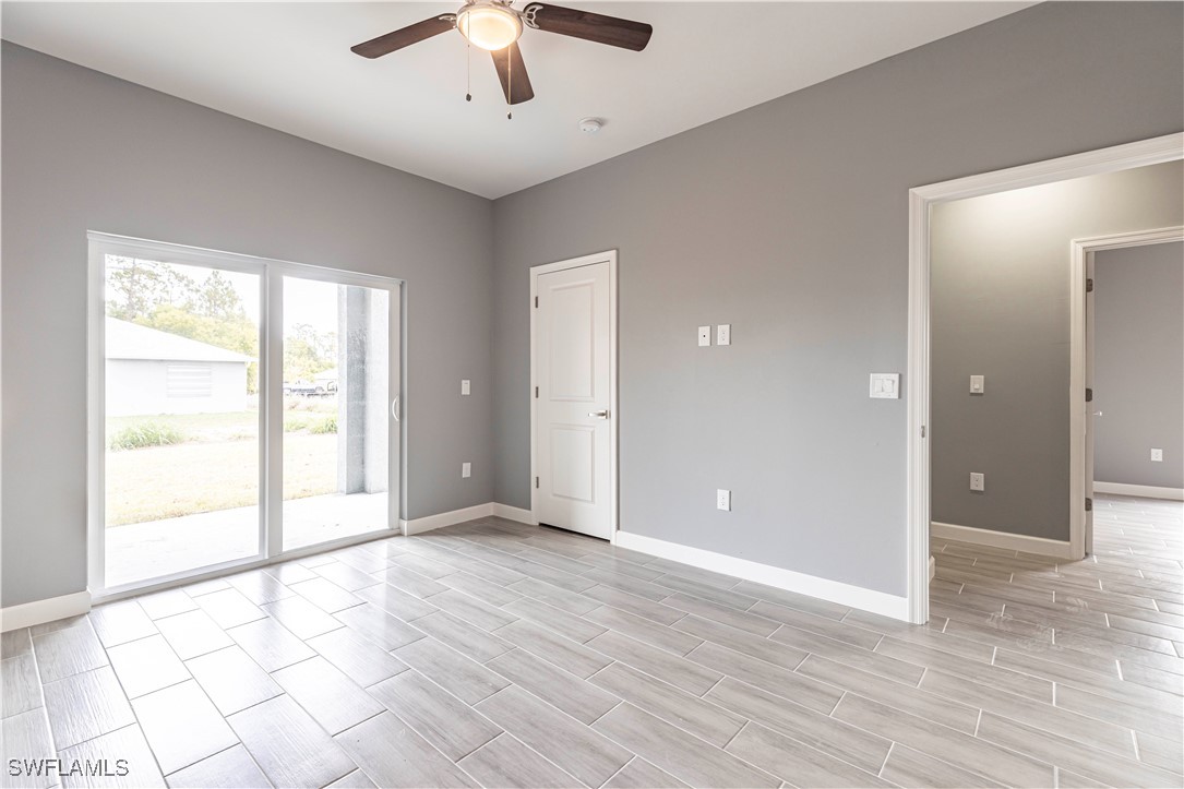 2422 Mae Avenue South Lehigh Acres, FL 33973 - Photo 14 of 28 an empty room with wooden floor and windows