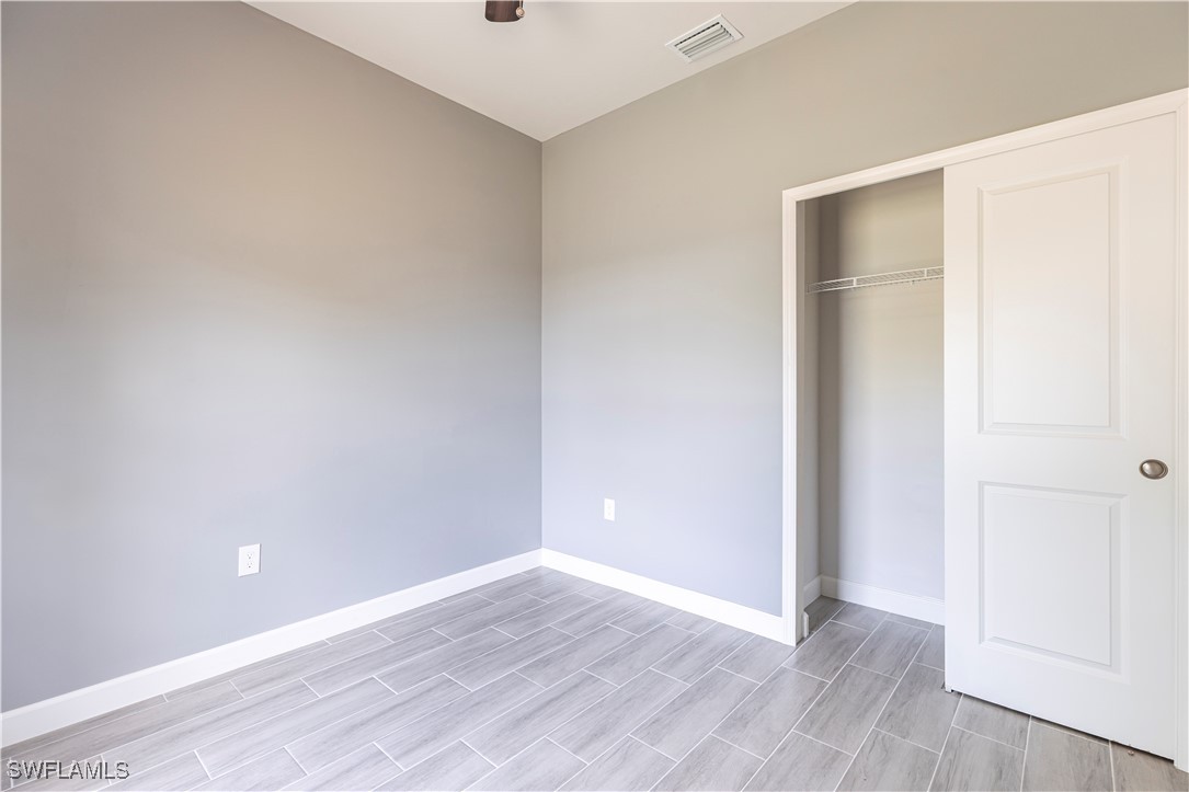 2422 Mae Avenue South Lehigh Acres, FL 33973 - Photo 19 of 28 a view of an empty room with wooden floor