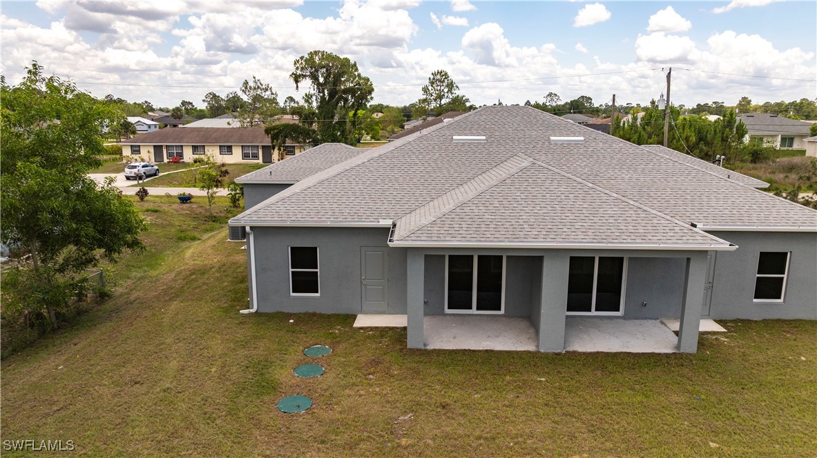 2422 Mae Avenue South Lehigh Acres, FL 33973 - Photo 25 of 28 a aerial view of a house next to a yard with plants and lake view