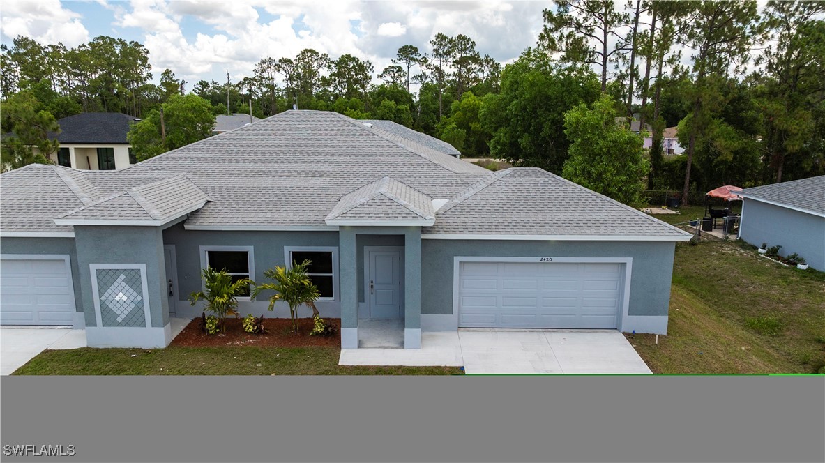 2422 Mae Avenue South Lehigh Acres, FL 33973 - Photo 28 of 28 a front view of a house with a yard and garage