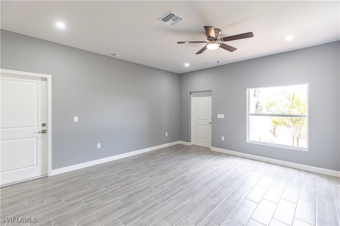 2422 Mae Avenue South Lehigh Acres, FL 33973 - Photo 7 of 28 wooden floor in an empty room with a window