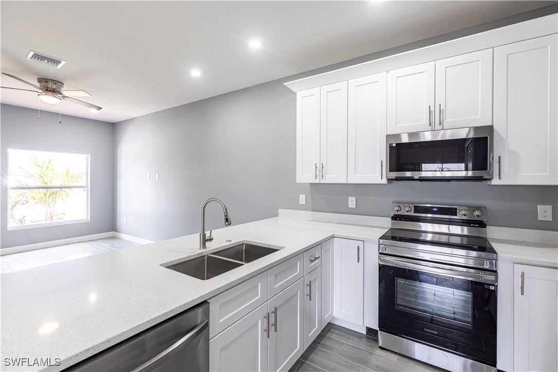 2422 Mae Avenue South Lehigh Acres, FL 33973 - Photo 10 of 28 a kitchen with sink a microwave and cabinets