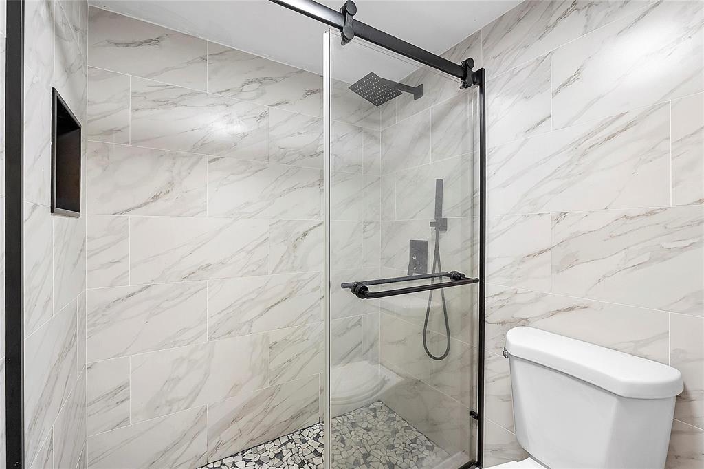 3955 North Nob Hill Road, Unit 404 Sunrise, FL 33351 - Photo 3 of 14 a bathroom with a granite countertop shower and a toilet