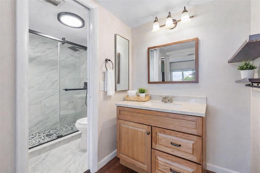 3955 North Nob Hill Road, Unit 404 Sunrise, FL 33351 - Photo 4 of 14 a bathroom with a shower sink and mirror