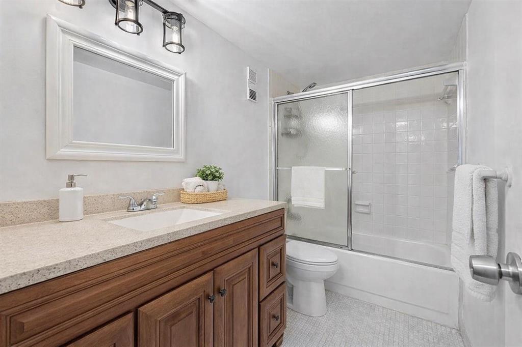 3955 North Nob Hill Road, Unit 404 Sunrise, FL 33351 - Photo 8 of 14 a bathroom with a granite countertop sink a toilet and a shower
