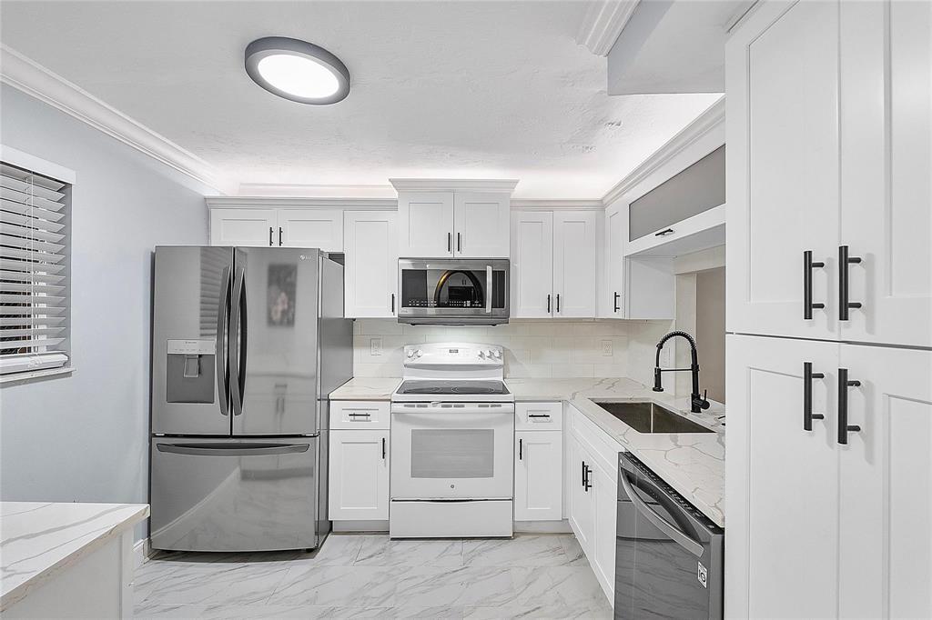 3955 North Nob Hill Road, Unit 404 Sunrise, FL 33351 - Photo 9 of 14 a kitchen with stainless steel appliances a refrigerator stove and microwave
