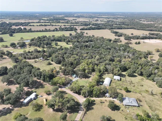an aerial view of house with yard and mountain view in back