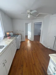 a view of a kitchen with a sink and wooden floor