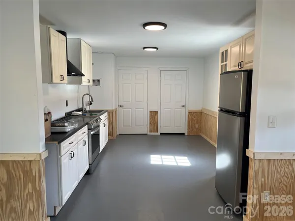 a kitchen with a white cabinets and refrigerator
