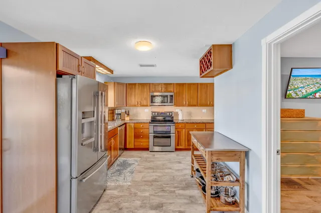 a kitchen with stainless steel appliances a refrigerator and a stove top oven