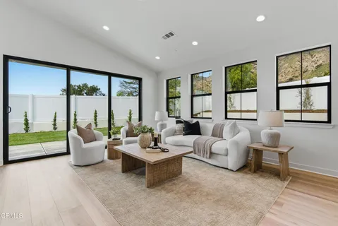 a living room with furniture couches and large window with outer view