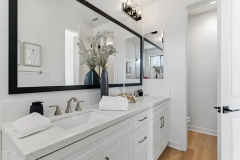 a bathroom with double vanity sinks and a mirror