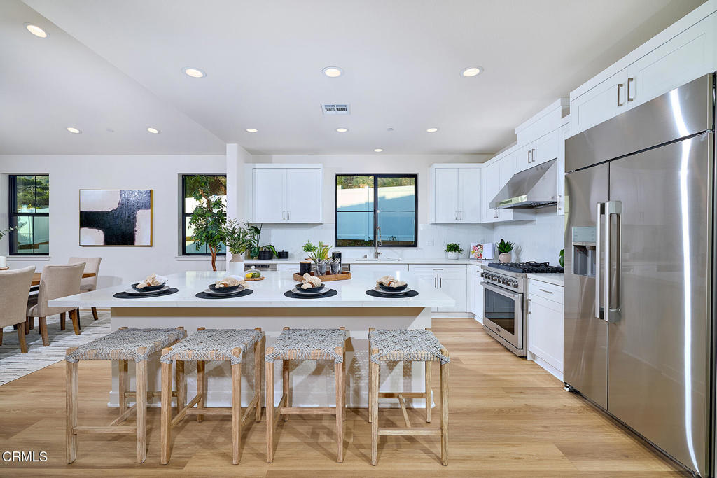 3245 Arrowhead Court Altadena, CA 91001 - Photo 5 of 37 a kitchen with stainless steel appliances kitchen island granite countertop a refrigerator a stove a sink a dining table and chairs