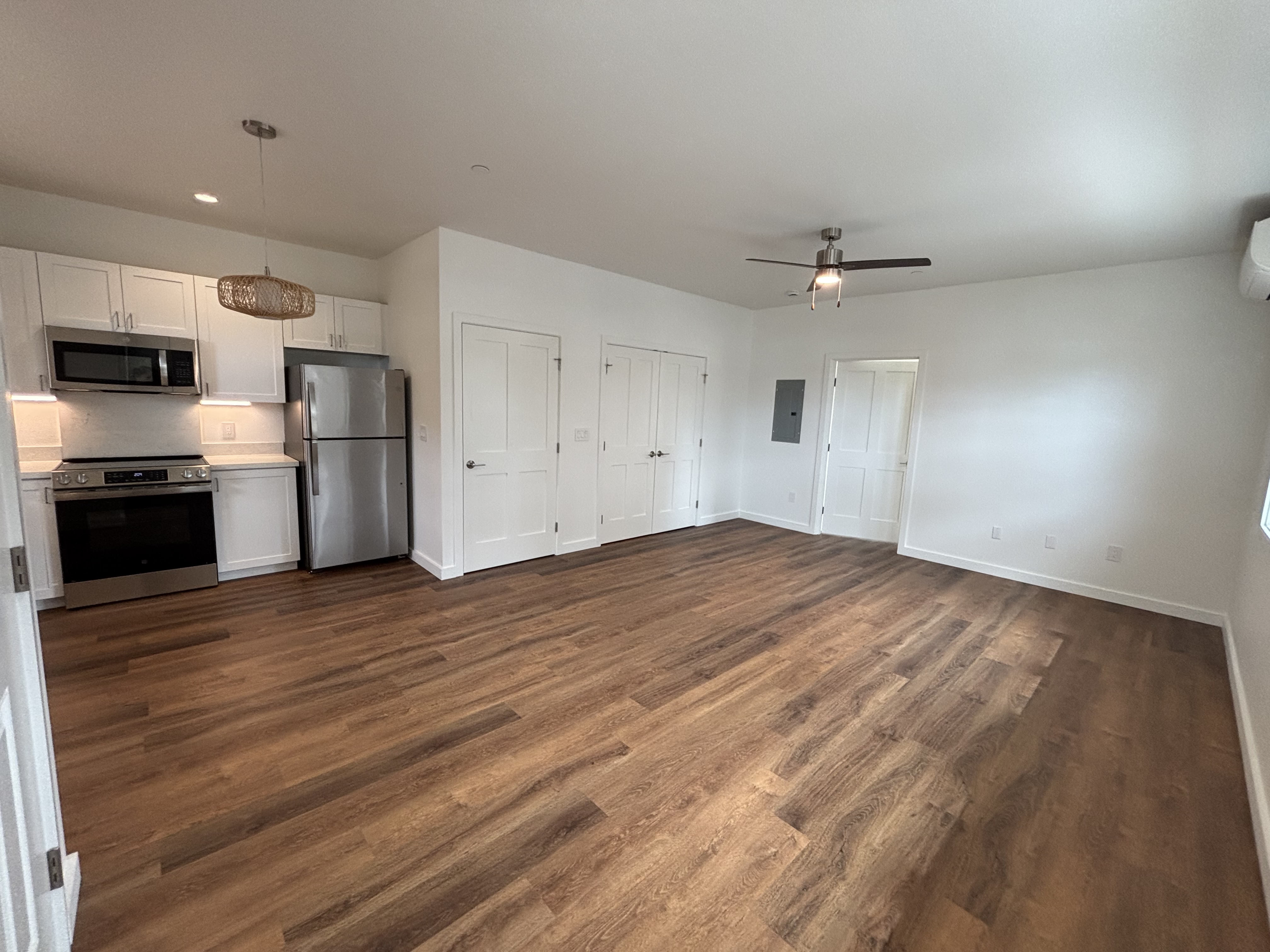 3451 Waikomo Road, Unit D102 Koloa, HI 96756 - Photo 8 of 15 an empty room with wooden floor kitchen view and a refrigerator