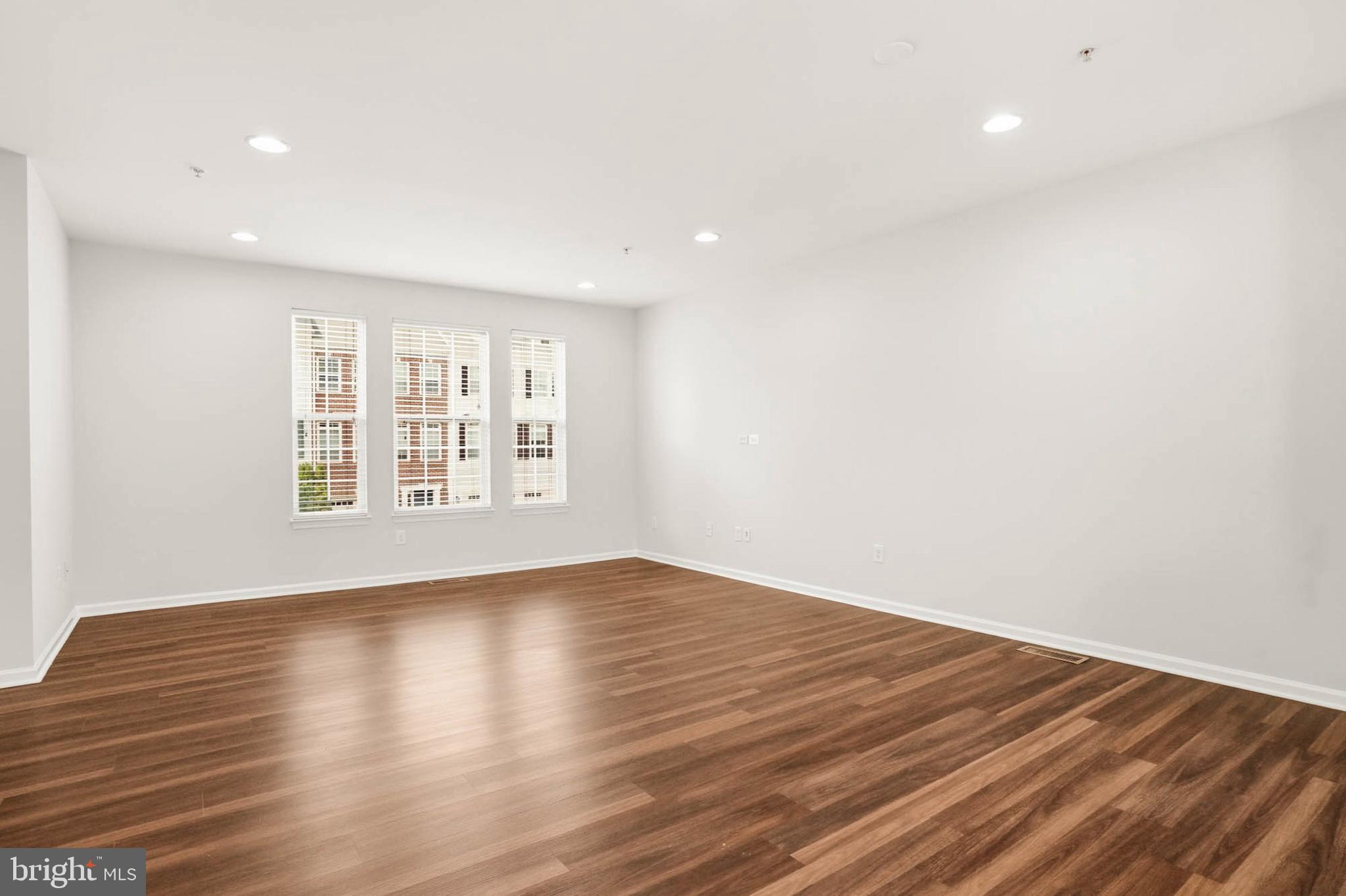 9817 Solar Course Laurel, MD 20723 - Photo 12 of 59 a view of an empty room with wooden floor and a window