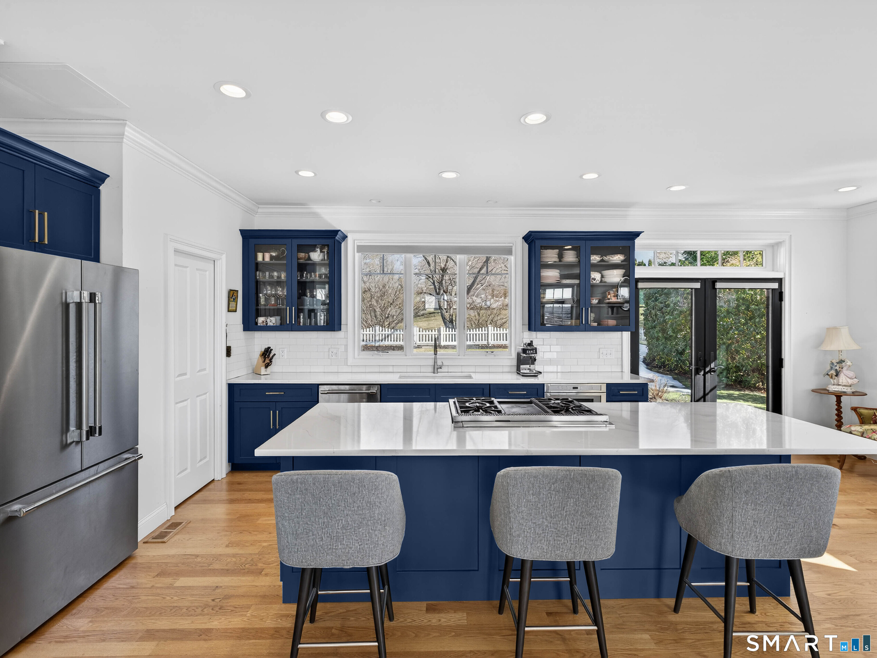 77 Masons Island Road Stonington, CT 06355 - Photo 11 of 35 a kitchen with stainless steel appliances granite countertop a table chairs stove and refrigerator