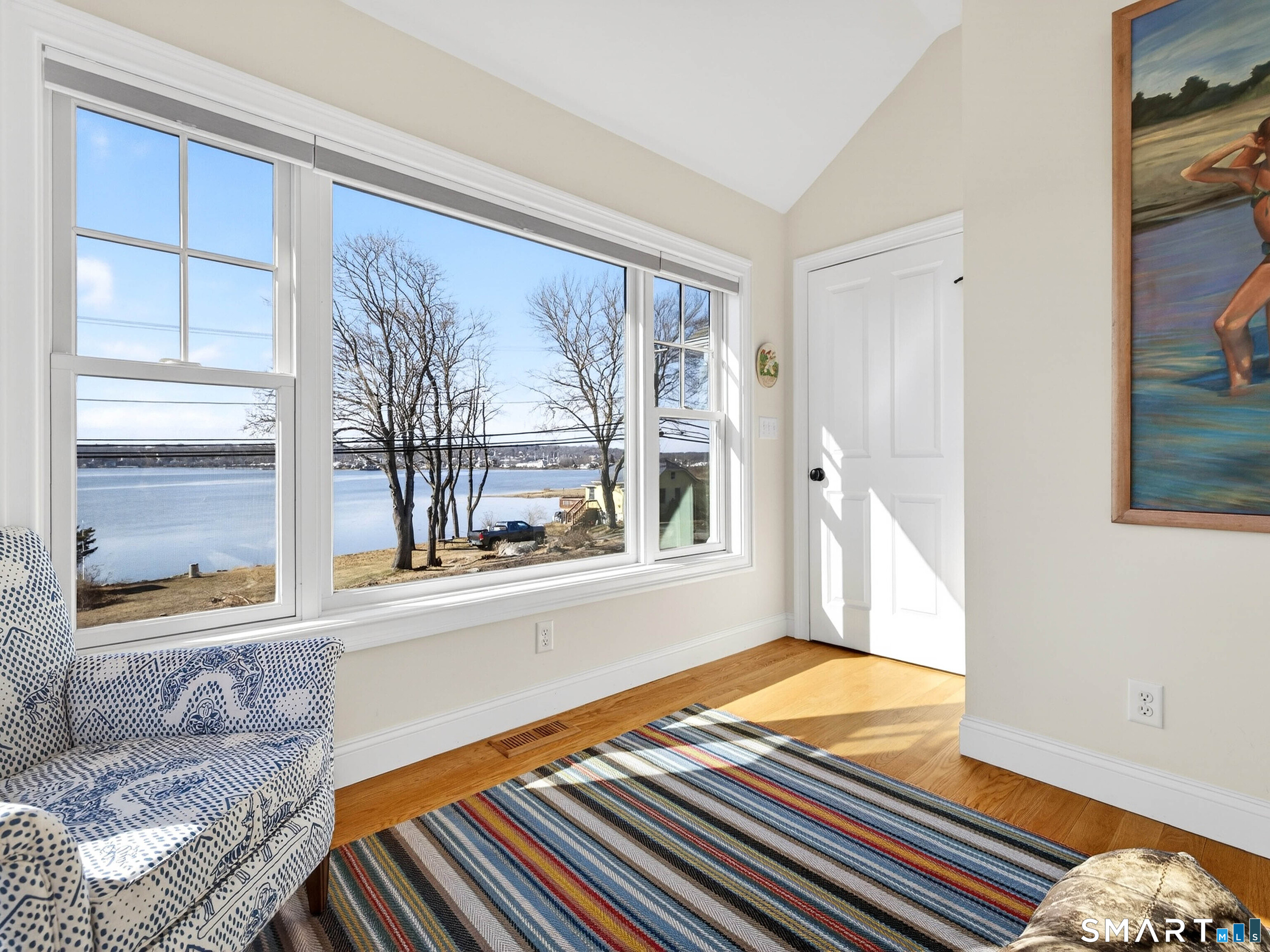 77 Masons Island Road Stonington, CT 06355 - Photo 12 of 35 a living room with a large window and a table