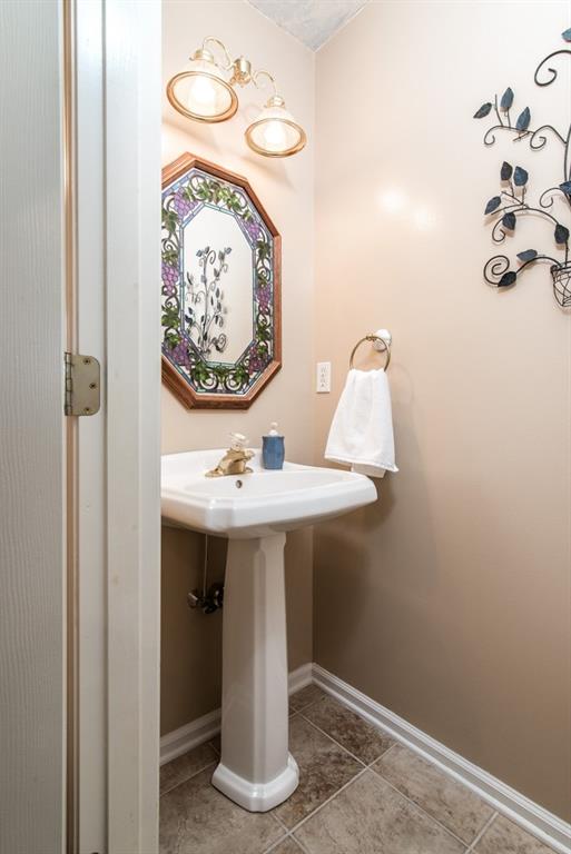 225 Logan Road Valencia, PA 16059 - Photo 13 of 25 First floor powder room with the same ceramic tile throughout the hallway, kitchen, mudroom/laundry room.