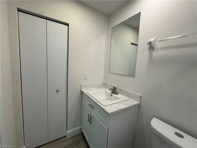 an empty room with wooden floor chandelier fan and windows