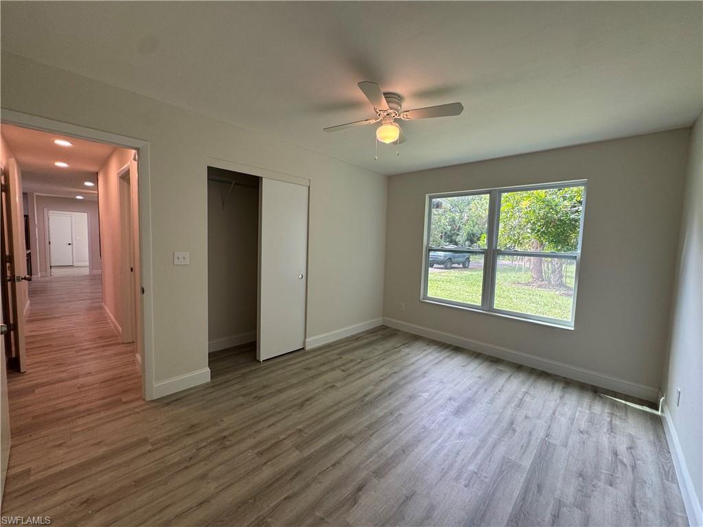 221 18th Avenue Northwest Naples, FL 34120 - Photo 13 of 22 a view of an empty room with wooden floor and a window