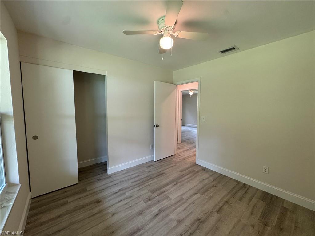 221 18th Avenue Northwest Naples, FL 34120 - Photo 14 of 22 an empty room with wooden floor and a ceiling fan