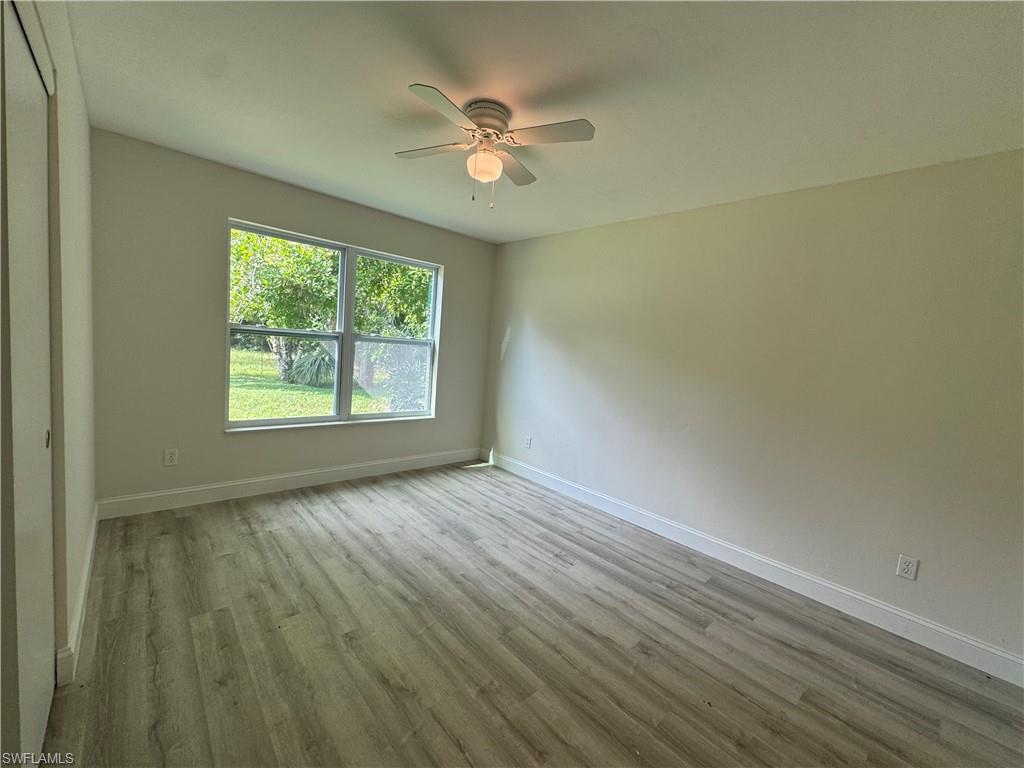 221 18th Avenue Northwest Naples, FL 34120 - Photo 15 of 22 an empty room with windows and ceiling fan