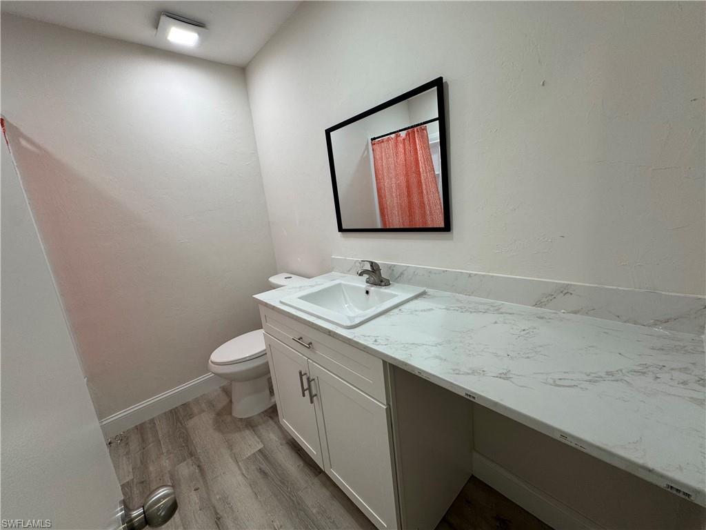 221 18th Avenue Northwest Naples, FL 34120 - Photo 18 of 22 a bathroom with a granite countertop sink mirror vanity and toilet