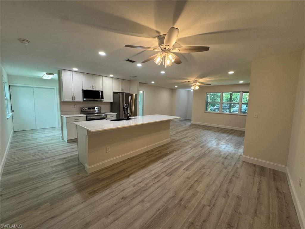 221 18th Avenue Northwest Naples, FL 34120 - Photo 22 of 22 a large kitchen with kitchen island a island wooden floors stainless steel appliances and a window