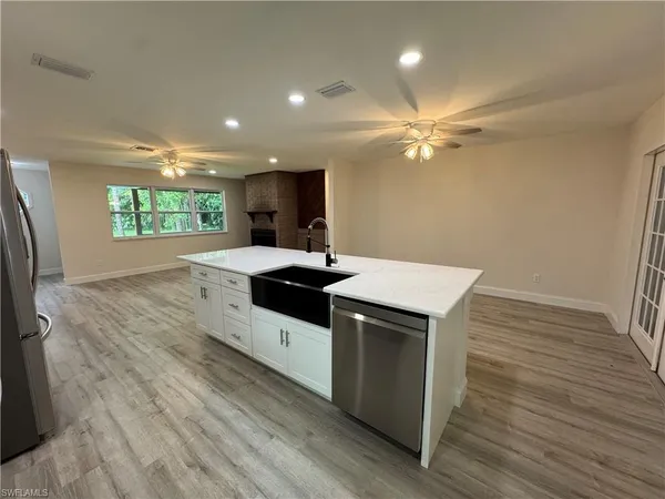 a kitchen with a microwave a sink dishwasher a refrigerator and a stove with wooden floor