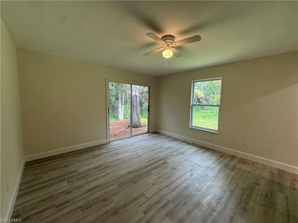 221 18th Avenue Northwest Naples, FL 34120 - Photo 7 of 22 a view of an empty room with a window and wooden floor