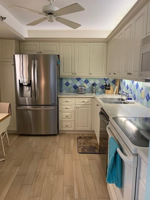 300 Ocean Trail Way, Unit 602 Jupiter, FL 33477 - Photo 3 of 17 a kitchen with stainless steel appliances granite countertop a refrigerator a sink a stove and white cabinets