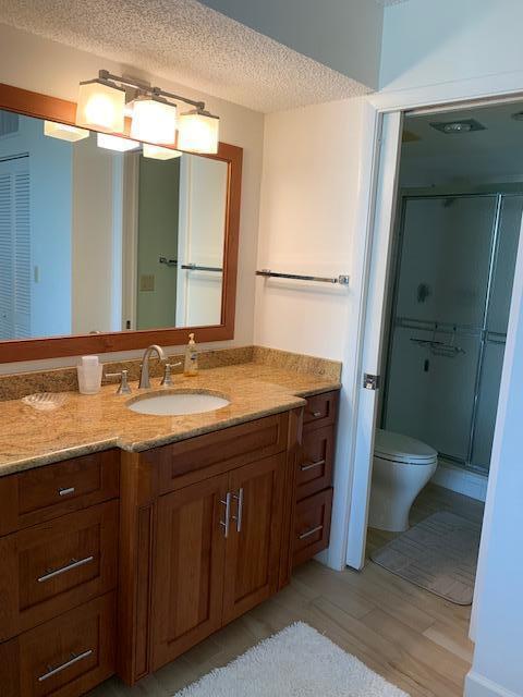300 Ocean Trail Way, Unit 602 Jupiter, FL 33477 - Photo 6 of 17 a bathroom with a granite countertop sink toilet and mirror