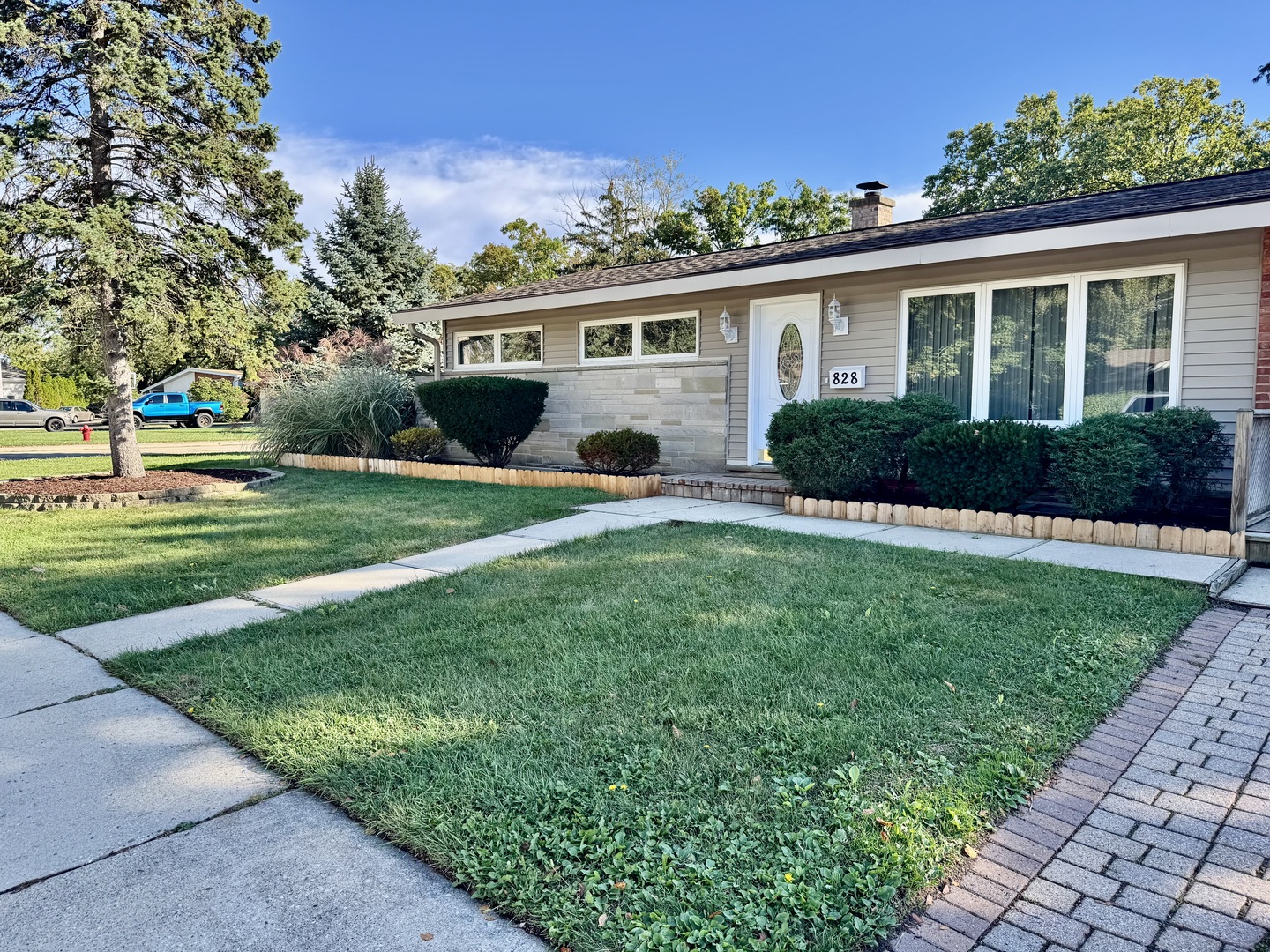 828 Dell Road Northbrook, IL 60062 - Photo 35 of 37 a front view of a house with a yard and potted plants