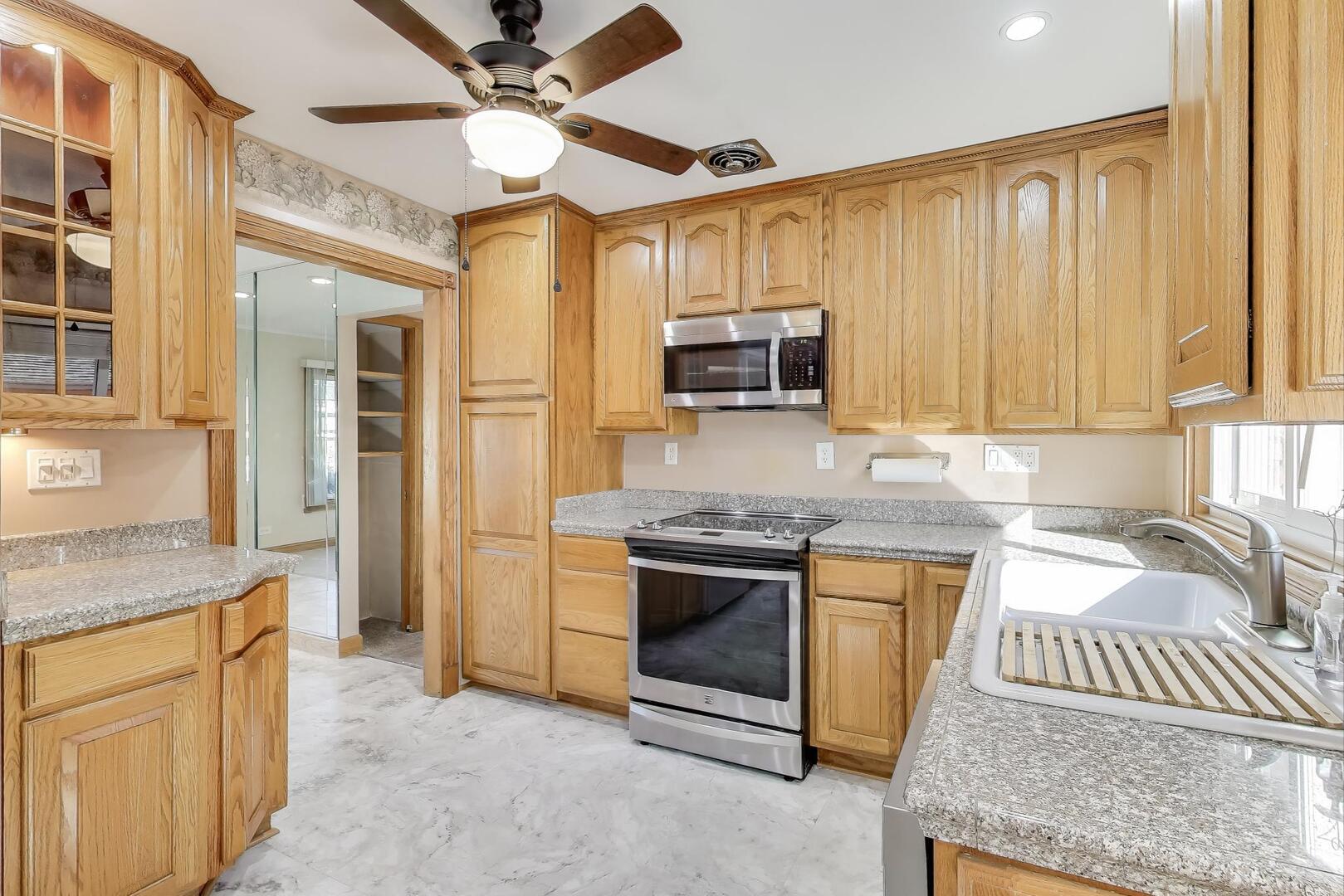 828 Dell Road Northbrook, IL 60062 - Photo 7 of 37 a kitchen with stainless steel appliances granite countertop a stove a sink and a refrigerator