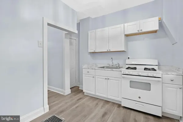 a kitchen with granite countertop white cabinets and white appliances