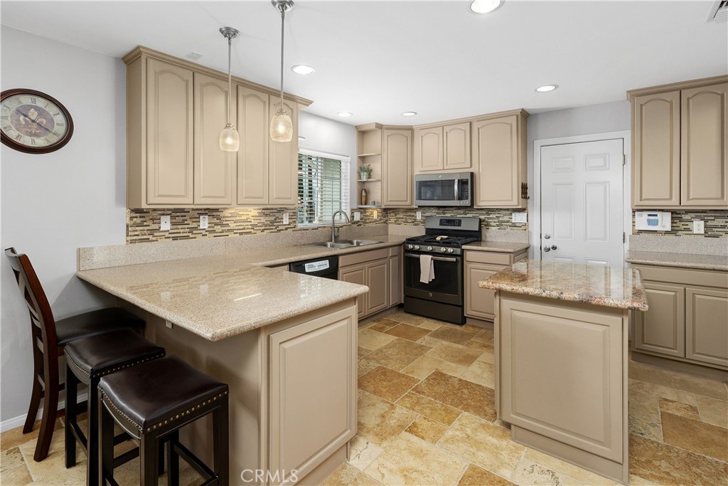 34990 County Line Road Yucaipa, CA 92399 - Photo 16 of 51 a kitchen with stainless steel appliances a stove a sink a microwave a dining table and chairs