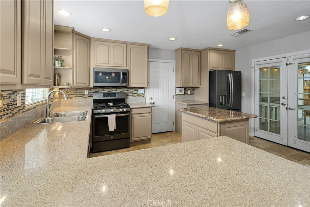 34990 County Line Road Yucaipa, CA 92399 - Photo 17 of 51 a kitchen with stainless steel appliances a stove a sink and a microwave