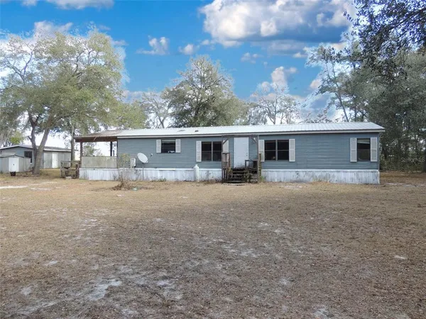 a front view of a house with a yard and outdoor seating