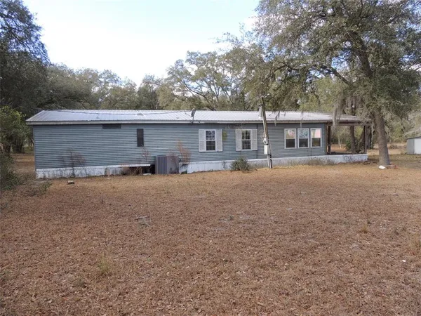 a front view of house with yard and trees