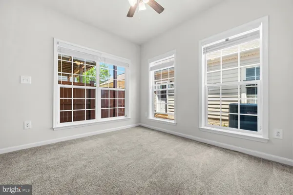 a view of an empty room with a window and a ceiling fan