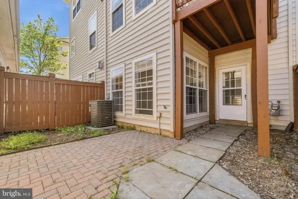 a view of backyard with large window and wooden fence