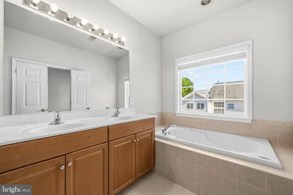 a bathroom with a tub a sink and mirror