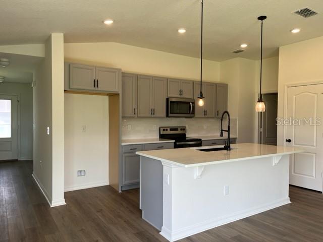 2792 Mdw Strm Way Clermont, FL 34714 - Photo 3 of 21 a kitchen with stainless steel appliances a stove a sink a refrigerator a center island and wooden floor