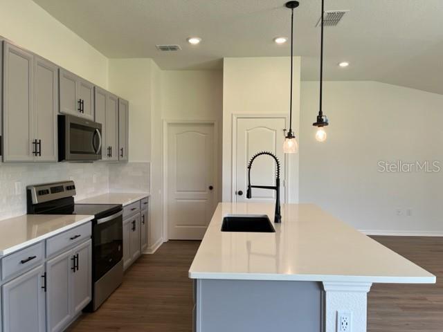 2792 Mdw Strm Way Clermont, FL 34714 - Photo 4 of 21 a kitchen with stainless steel appliances kitchen island a white counter top space cabinets and a wooden floor