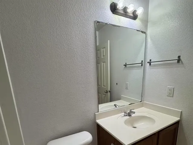 a bathroom with a sink toilet and mirror