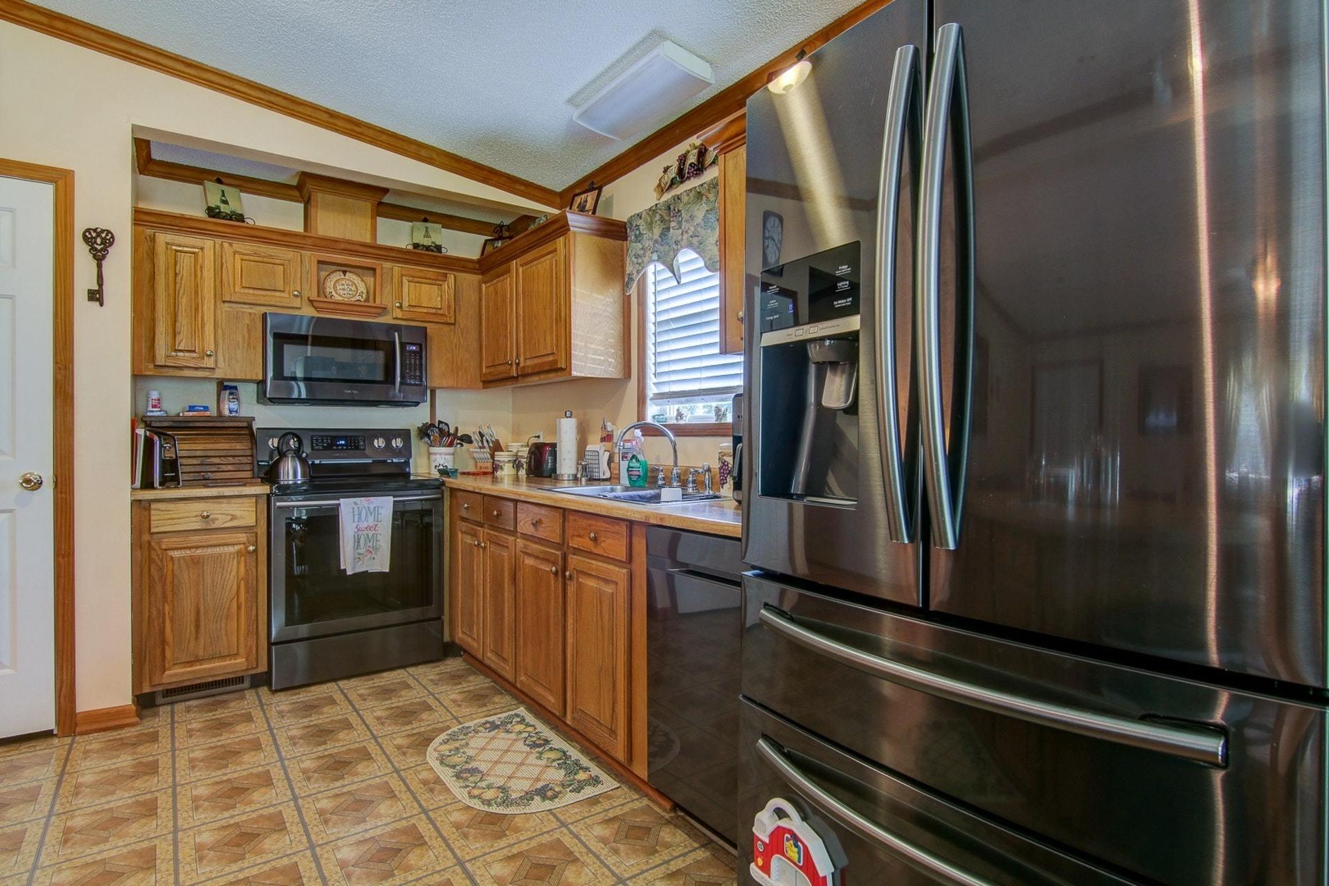 3762 Spradlin Road Goodview, VA 24095 - Photo 15 of 36 a kitchen with granite countertop a refrigerator and a stove top oven