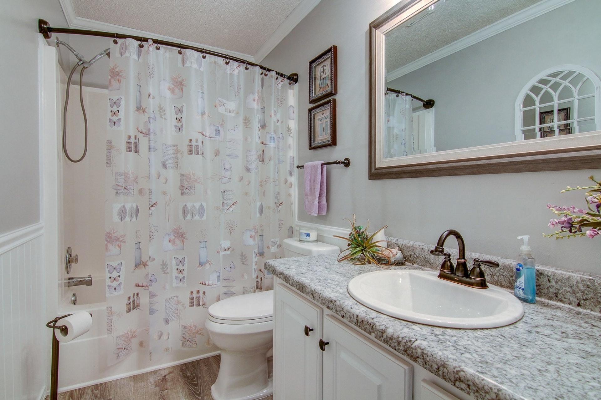 3762 Spradlin Road Goodview, VA 24095 - Photo 16 of 36 a bathroom with a granite countertop sink a toilet and a shower