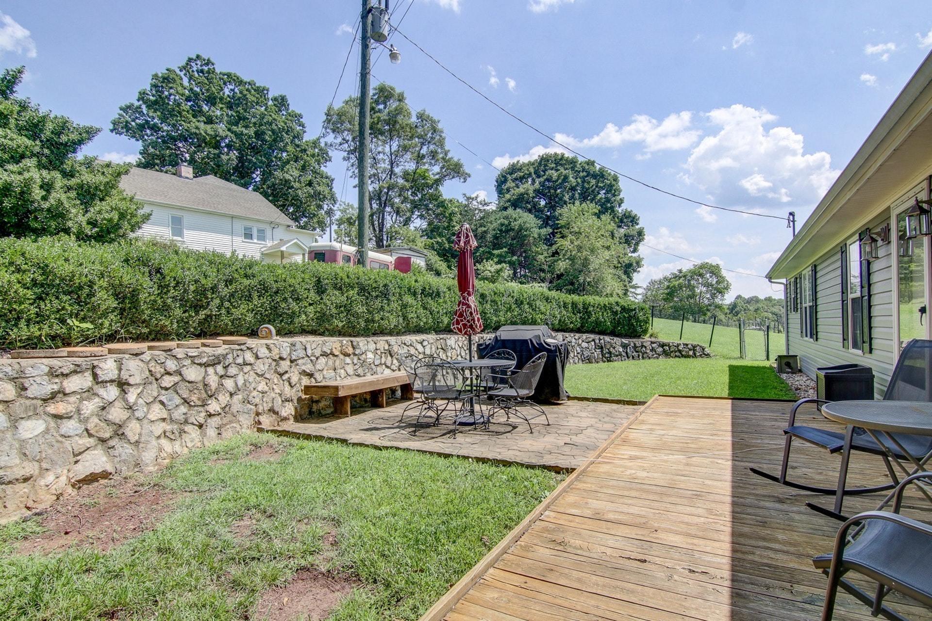 3762 Spradlin Road Goodview, VA 24095 - Photo 27 of 36 a view of a patio with table and chairs potted plants with wooden fence