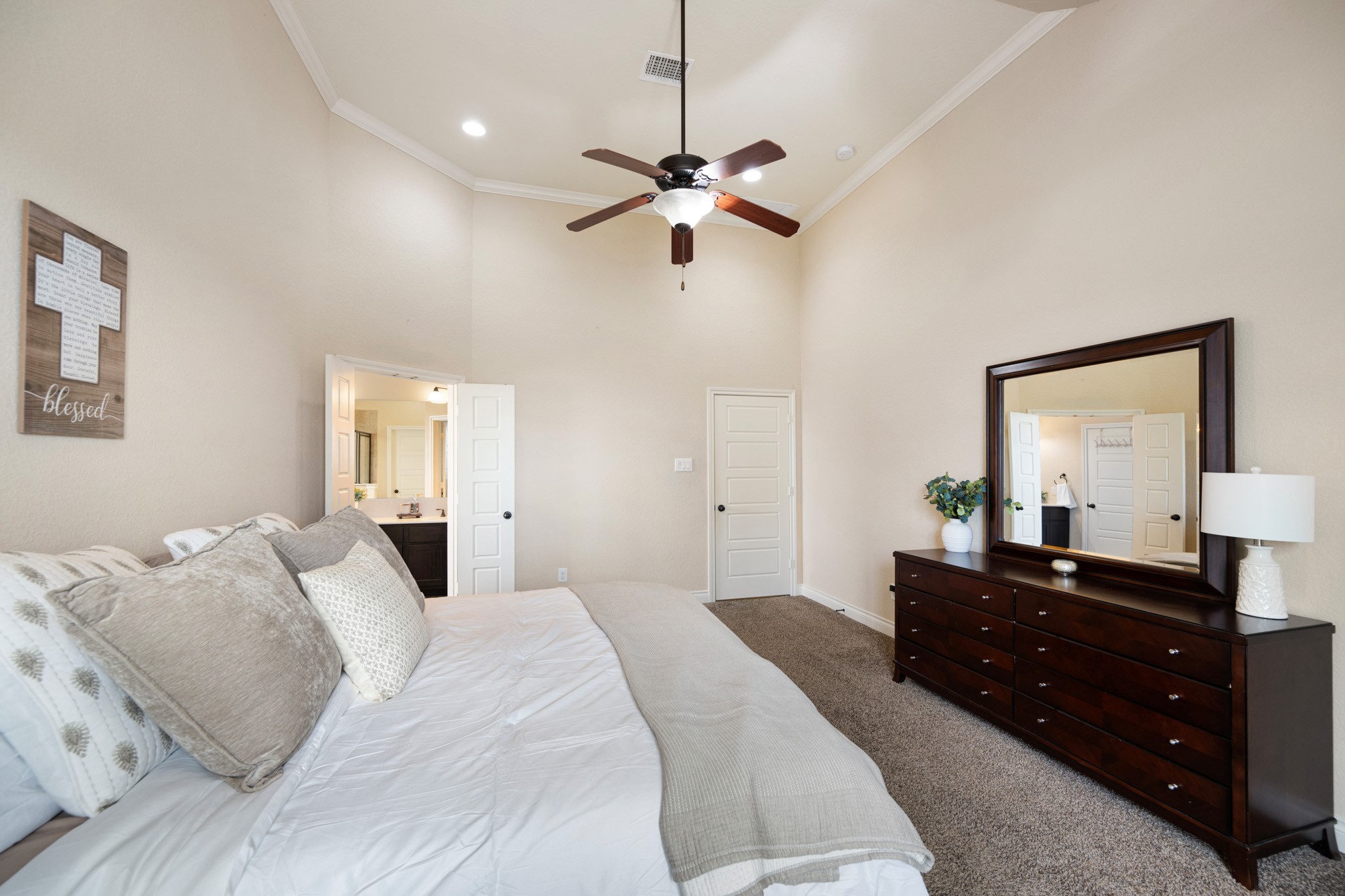 8131 Brinkmeyer Road Needville, TX 77461 - Photo 21 of 34 Spacious primary bedroom with high ceilings, neutral tones, and plush carpeting.